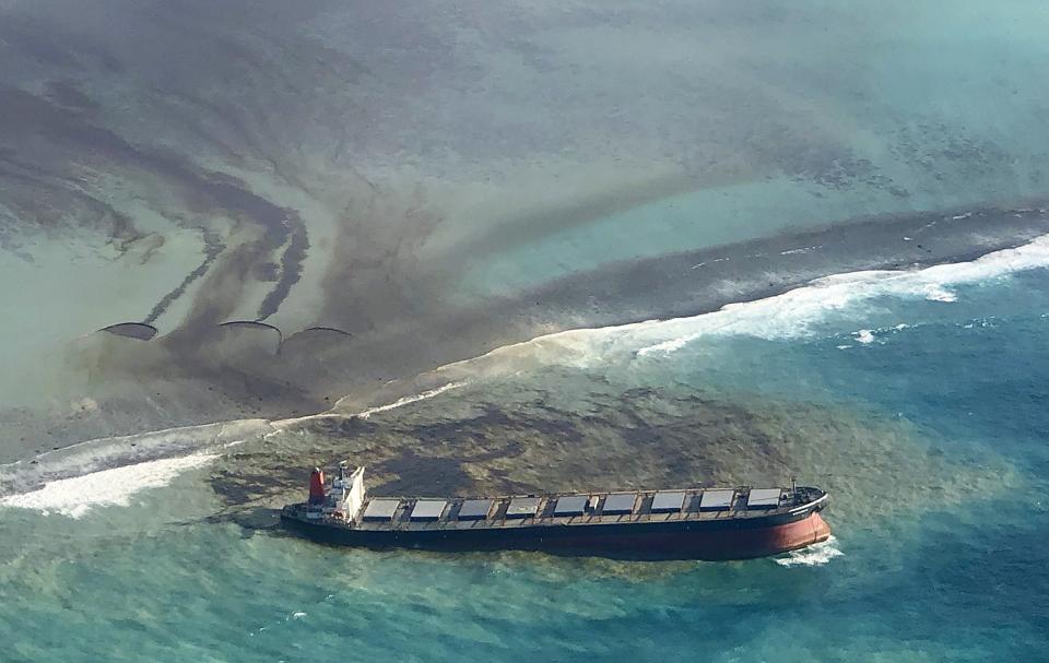 This photo taken and provided by Eric Villars shows oil leaking from the MV Wakashio, a bulk carrier ship that recently ran aground off the southeast coast of Mauritius, Friday, Aug. 7, 2020. Anxious residents of the Indian Ocean island nation of Mauritius are stuffing fabric sacks with sugar cane leaves to create makeshift oil spill barriers as tons of fuel leak from a grounded ship. The government has declared an environmental emergency and France says it is sending help from its nearby Reunion island. (Eric Villars via AP)