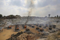 Funeral pyres of twenty-five COVID-19 victims burn at an open crematorium set up at a granite quarry on the outskirts of Bengaluru, India, Wednesday, May 5, 2021. (AP Photo/Aijaz Rahi)