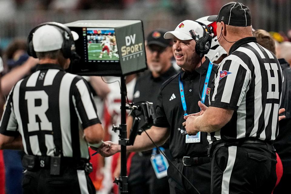 Louisville coach Jeff Brohm talks to the officials during a replay review during Friday's game against Georgia Tech.