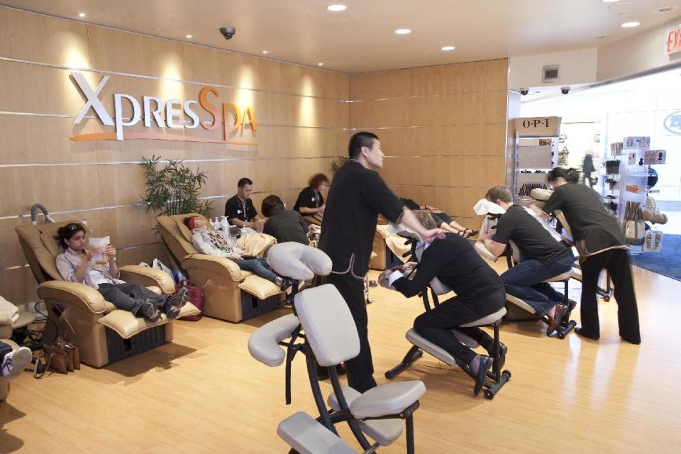 This undated image provided by XpresSpa shows the customers receiving massages and other treatments at the company’s spa at John F. Kennedy International Airport in New York. XpresSpa offers manicures, pedicures, massages, haircuts and other treatments at 46 airport locations and sells gift cards for their services that can be given as holiday gifts for travelers. (AP Photo/XpresSpa, Lance Davies)