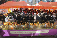 Parents place candles during a special service to wish for their children's success in the college entrance exams at the Jogyesa Buddhist temple in Seoul, South Korea, Thursday, Dec. 3, 2020. Hundreds of thousands of masked students in South Korea, including dozens of confirmed COVID-19 patients, took the highly competitive university entrance exam Thursday despite a viral resurgence that forced authorities to toughen social distancing rules. (AP Photo/Ahn Young-joon)