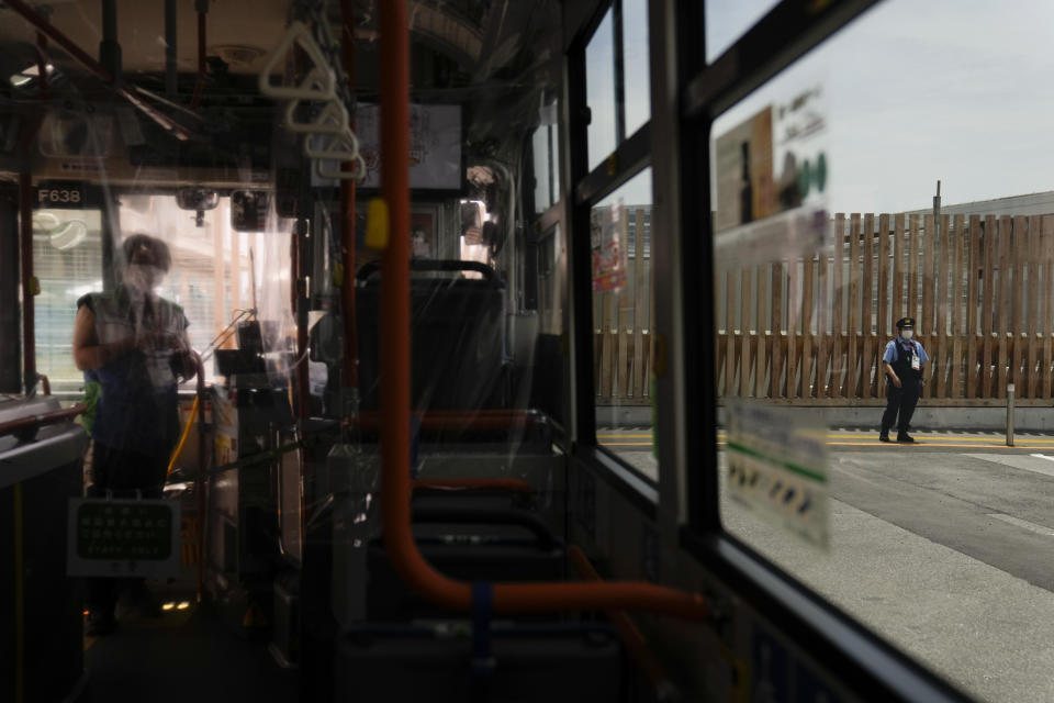 A police officer, right, patrols near the entrance to the athlete's village for the 2020 Summer Olympics and Paralympics, Thursday, July 15, 2021, in Tokyo. (AP Photo/Jae C. Hong)