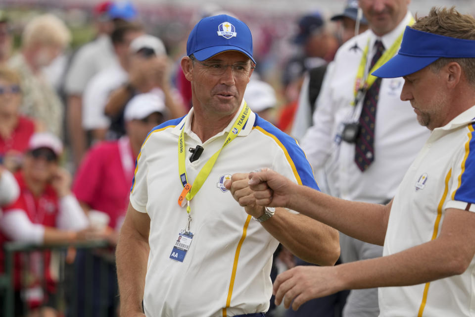 Team Europe captain Padraig Harrington talks to Team Europe's Ian Poulter on the 15th hole during a Ryder Cup singles match at the Whistling Straits Golf Course Sunday, Sept. 26, 2021, in Sheboygan, Wis. (AP Photo/Charlie Neibergall)