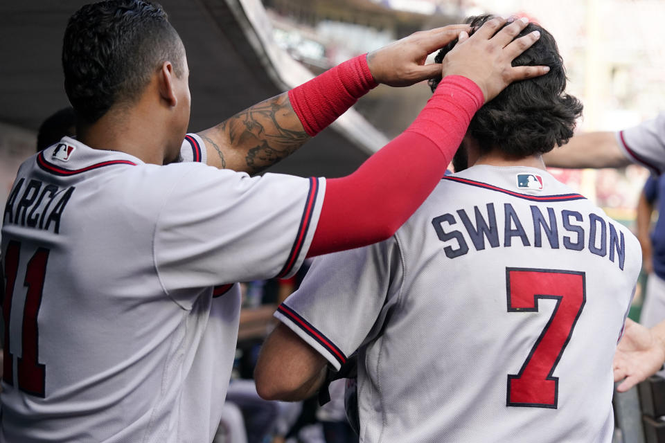 Atlanta Braves' Dansby Swanson (7) celebrates with Orlando Arcia after scoring on a double by Austin Riley during the seventh inning of the team's baseball game against the Cincinnati Reds on Saturday, July 2, 2022, in Cincinnati. (AP Photo/Jeff Dean)