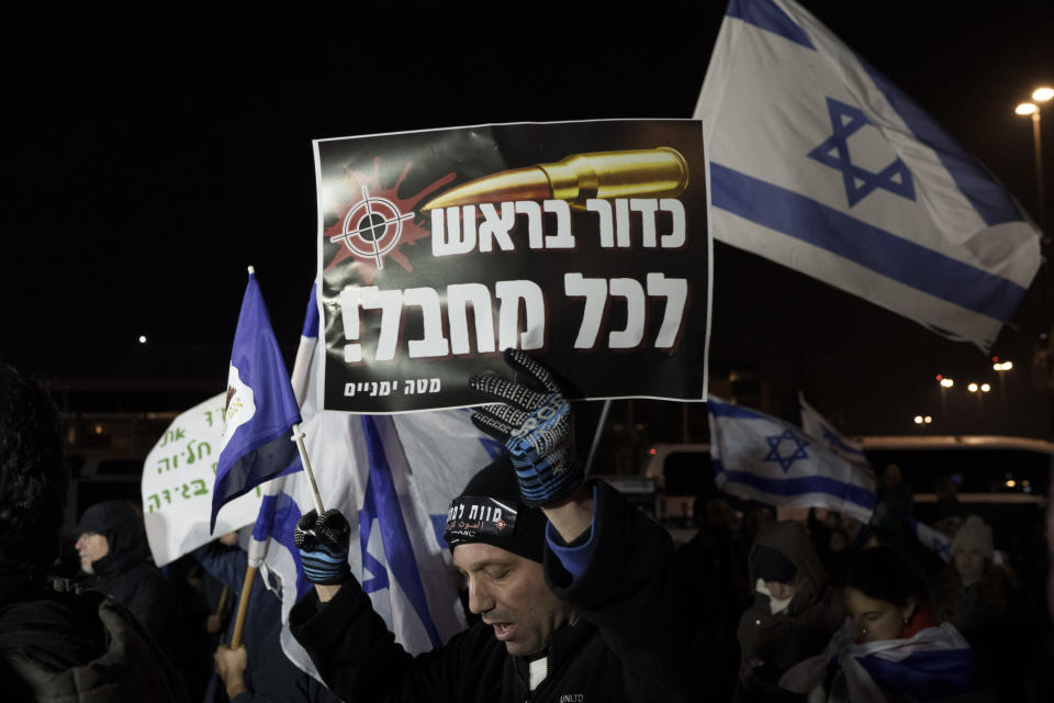 A man holds up a sign that reads in Hebrew "a bullet in the head for every terrorist" as he takes part in a protest against humanitarian aid entering Gaza and against the hostages exchange deal with Hamas, in Jerusalem, Israel, Thursday, Jan. 25, 2024. (AP Photo/Leo Correa)