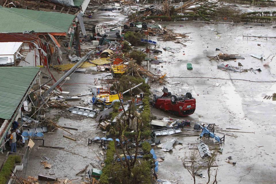 A damaged car is seen in front of the airport after super Typhoon Haiyan battered Tacloban city, central Philippines, November 9, 2013. Possibly the strongest typhoon ever to hit land devastated the central Philippine city of Tacloban, killing at least 100 people, turning houses into rubble and leveling the airport in a surge of flood water and high wind, officials said on Saturday. The toll of death and damage from Typhoon Haiyan on Friday is expected to rise sharply as rescue workers and soldiers reach areas cut off by the massive, fast-moving storm which weakened to a category 4 on Saturday. REUTERS/Romeo Ranoco (PHILIPPINES - Tags: DISASTER ENVIRONMENT)