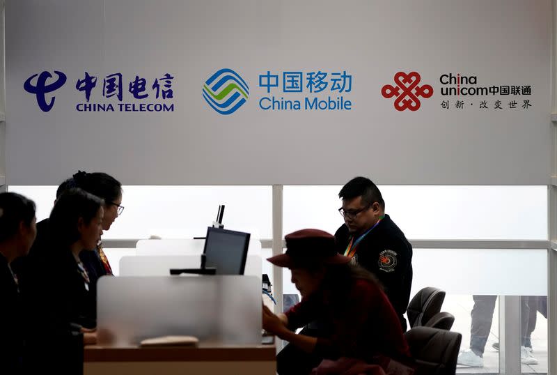 FILE PHOTO: Signs of China Telecom, China Mobile and China Unicom are seen during the China International Import Expo at the National Exhibition and Convention Center in Shanghai