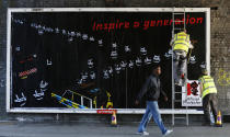 Guerrilla artists put up a billboard protesting the London 2012 Olympics in east London July 23, 2012. REUTERS/Suzanne Plunkett