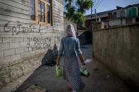 Sabu Sheikh, a transgender Kashmiri, walks homeward after collecting food handouts in Srinagar, Indian controlled Kashmir, Thursday, May 27, 2021. Kashmir's transgender are often only able to find work as matchmakers or wedding entertainment. Prolonged coronavirus lockdowns, preceded by a strict security lockdown in the region in 2019 when India scrapped Kashmir's semi-autonomous status, left many in the transgender community with no work at all. (AP Photo/ Dar Yasin)