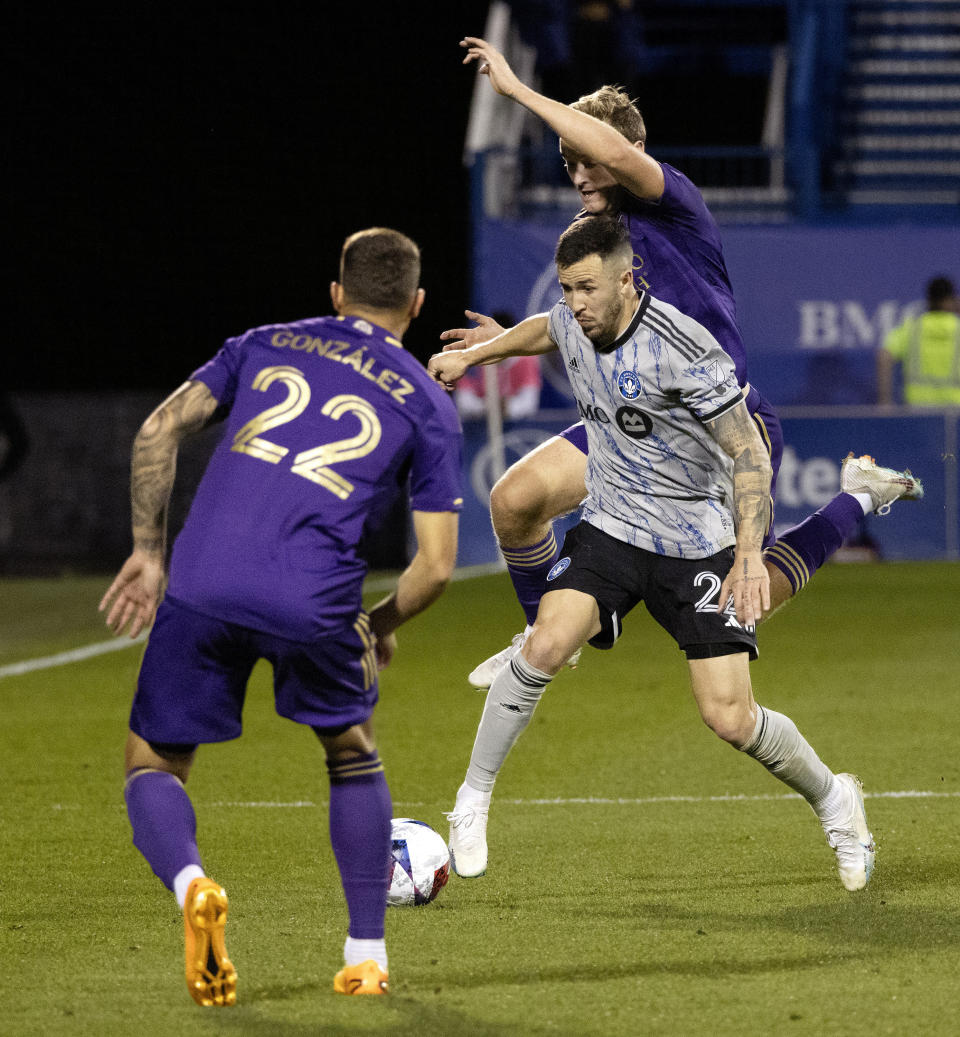 Orlando City forward Duncan McGuire tries to overtake CF Montreal defender Aaron Herrera as Orlando City forward Gaston Gonzalez looks on during the second half of an MLS soccer game in Montreal, Saturday, May 6, 2023. (Allen McInnis/The Canadian Press via AP)