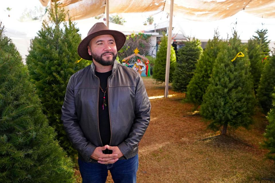 Jimmie Muñoz Jr. stands amongst the three different types of Christmas trees available at the Muñoz Family Christmas Tree Lot on Nov. 30, 2023. His family estimates they will sell around 800 trees from Oregon this year.