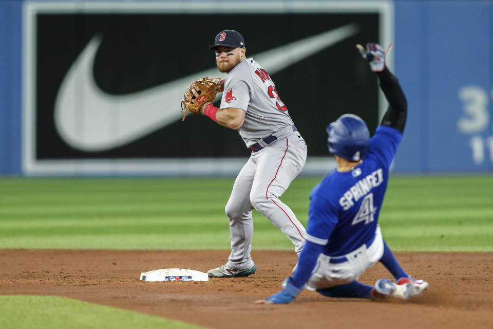 Boston Red Sox second baseman Christian Arroyo (39) forces out Toronto Blue Jays' George Springer (4) at second as he completes the double play with a throw to first base to out Blue Jays' Bo Bichette in the third inning of a baseball game in Toronto, Sunday, Oct. 2, 2022. (Cole Burston/The Canadian Press via AP)