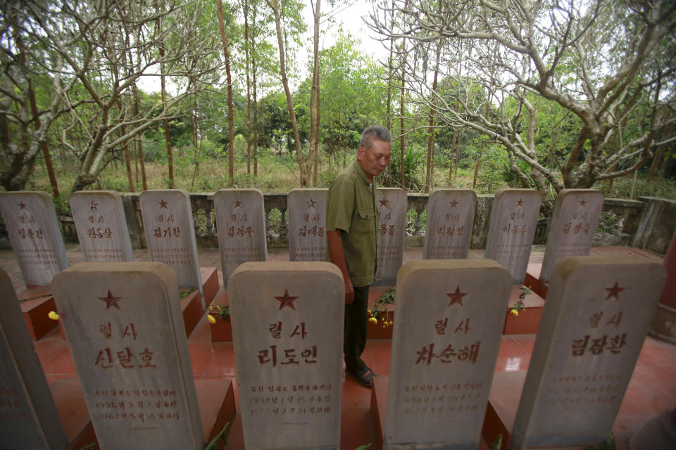 In this Feb. 16, 2019, photo, war veteran Duong Van Dau walks in between a row of headstones at a memorial for North Korean fallen pilots in Bac Giang province, Vietnam. The fourteen headstones of the pilots who died while fighting American bombers alongside the Vietnamese army during the Vietnam war remain as a symbol of Vietnam-North Korea friendship. (AP Photo/Hau Dinh)