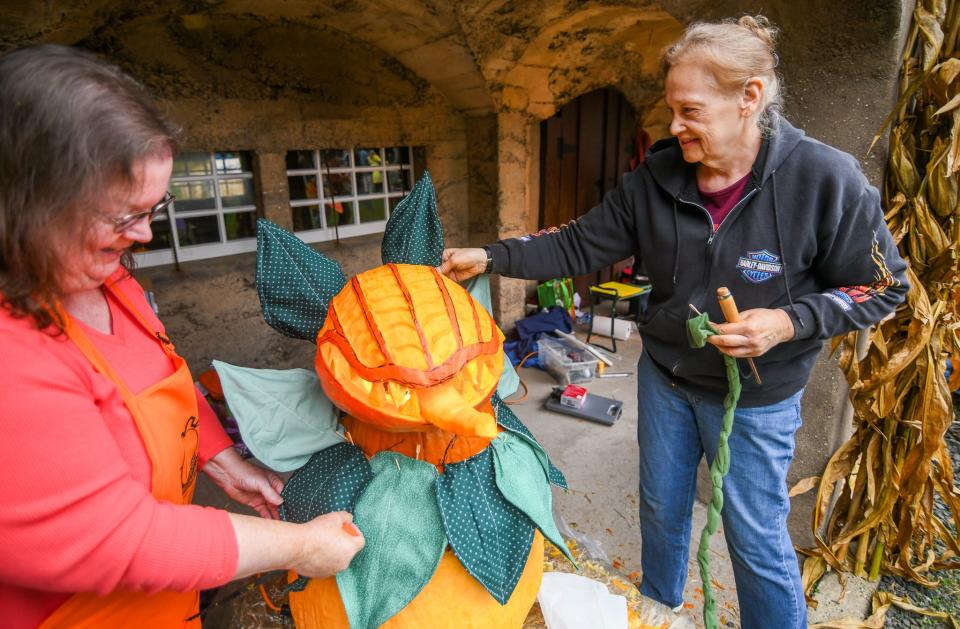 Pumpkin-carving artist Carolyn Gorham puts the finishing touches on her pumpkin, Audrey, inspired by “Little Shop of Horrors” during the CB Cares 2021 Pumpkinfest event Saturday at Bucks County Tile Works in Doylestown.