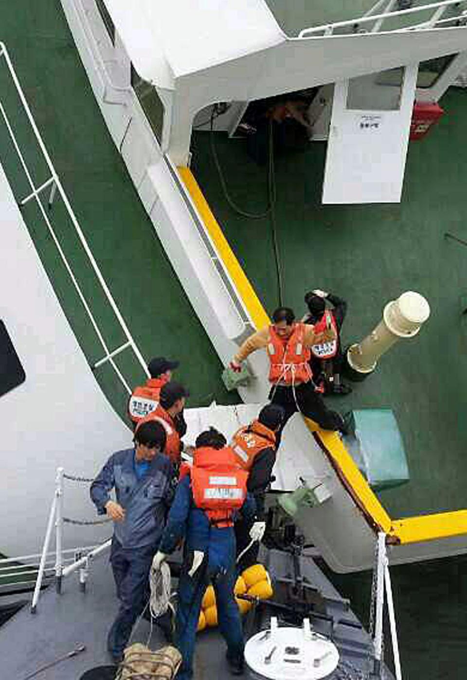Passengers are rescued by South Korean maritime policemen from a sinking ship "Sewol" in the sea off Jindo