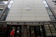 FILE PHOTO: A person stands at the entrance of the New York State Department of Labor offices, which closed to the public due to the coronavirus disease (COVID-19) outbreak in the Brooklyn borough of New York City,
