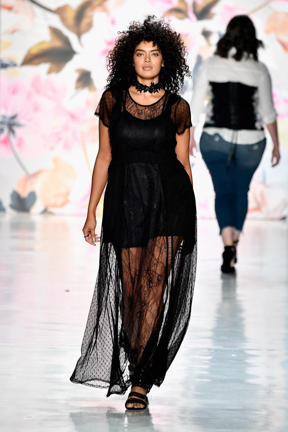 A model wears a sheer black lace dress at the Torrid show during NYFW. 