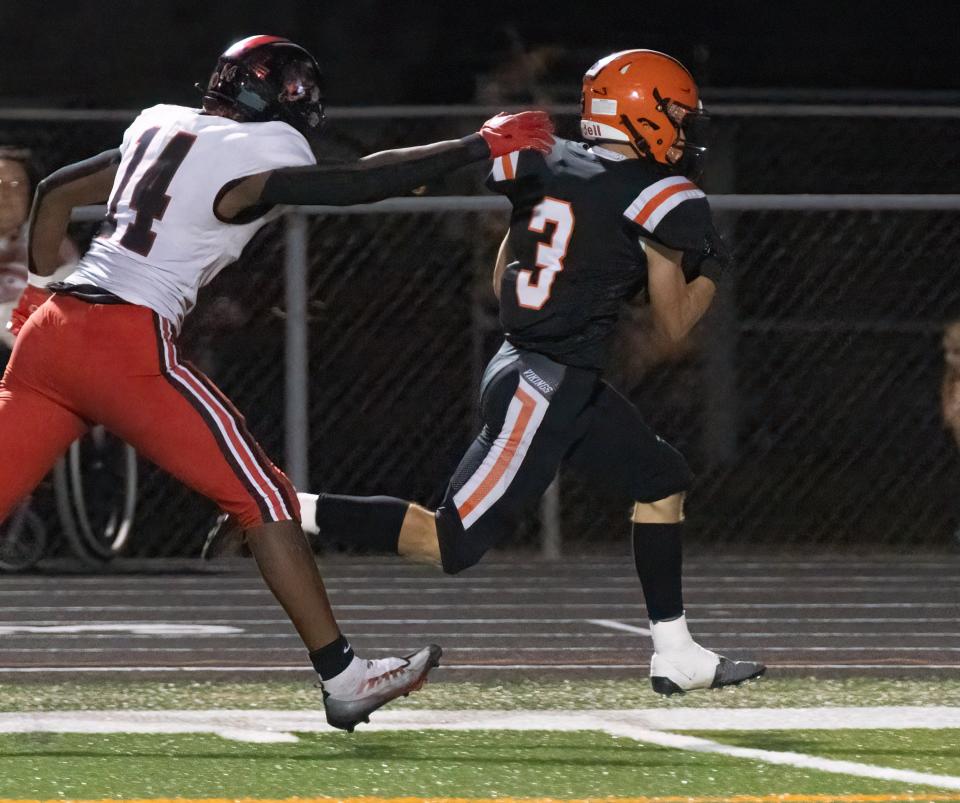 Hoover’s Mason Ashby breaks free from McKinley’s Ja’Diss Jackson to tie the game 28-28 in the third quarter, Friday, Sept. 22, 2023.