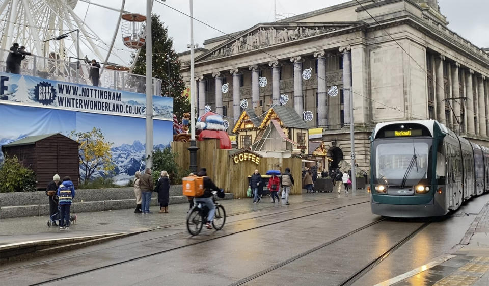 In this grab taken from video, people walk to a holiday market in Nottingham city centre, England, Nov. 18, 2023. The city is home to the Panthers of the Elite Ice Hockey League. Panthers forward Adam Johnson was living with his fiancée and studying at a business school. The 29-year-old American died after an opponent's skate cut his throat during a game on Oct. 28 in Sheffield. (AP Photo/Kenneth Maguire)