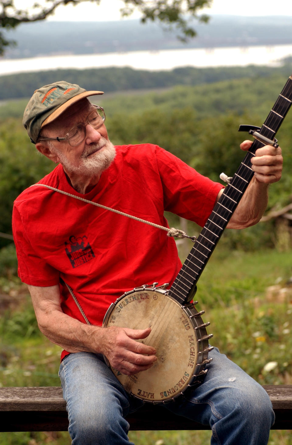 FILE - In this Tuesday, July 27, 2004 file photo, Pete Seeger, 85, sits on his porch above the Hudson River at Beacon, N.Y. and plays a Woody Guthrie song on his banjo. Seeger died on Monday Jan. 27, 2014, at the age of 94. (AP Photo/Jim McKnight)