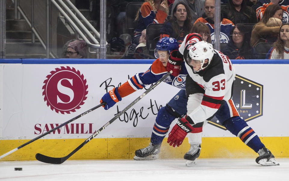New Jersey Devils' Ryan Graves (33) and Edmonton Oilers' Ryan McLeod (71) vie for the puck during the second period of an NHL hockey game Thursday, Nov. 3, 2022, in Edmonton, Alberta. (Jason Franson/The Canadian Press via AP)