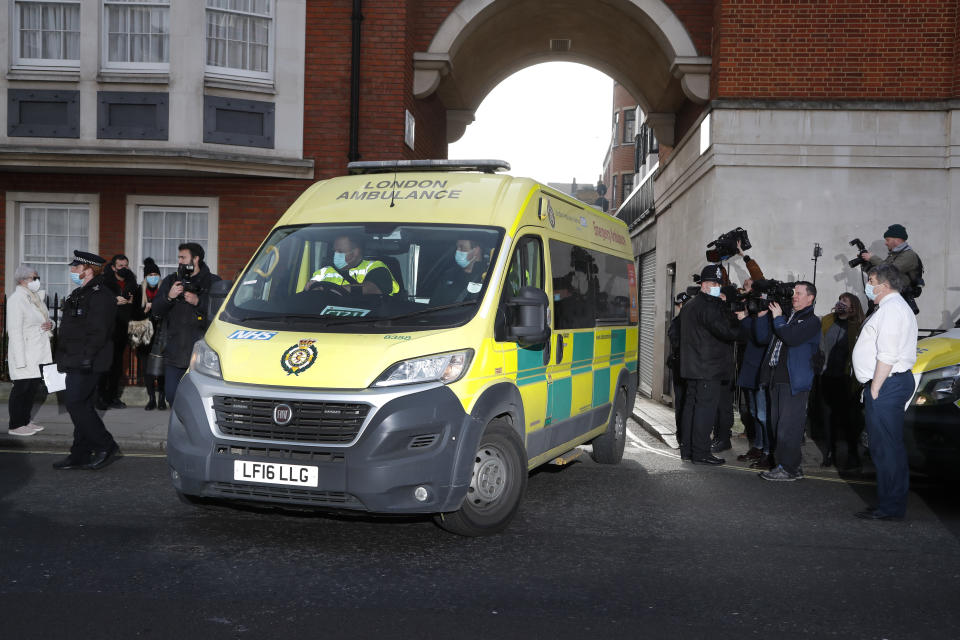 Police officers stand at an entrance to the King Edward VII Hospital where Prince Philip is being treated for an infection, as an ambulance is driven out, in London, Monday, March 1, 2021. (AP Photo/Frank Augstein)