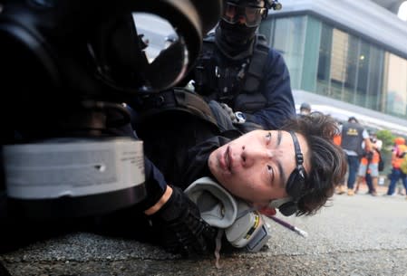 A man lies down as riot police officers clash with anti-government protesters demonstrating in Admiralty district, Hong Kong