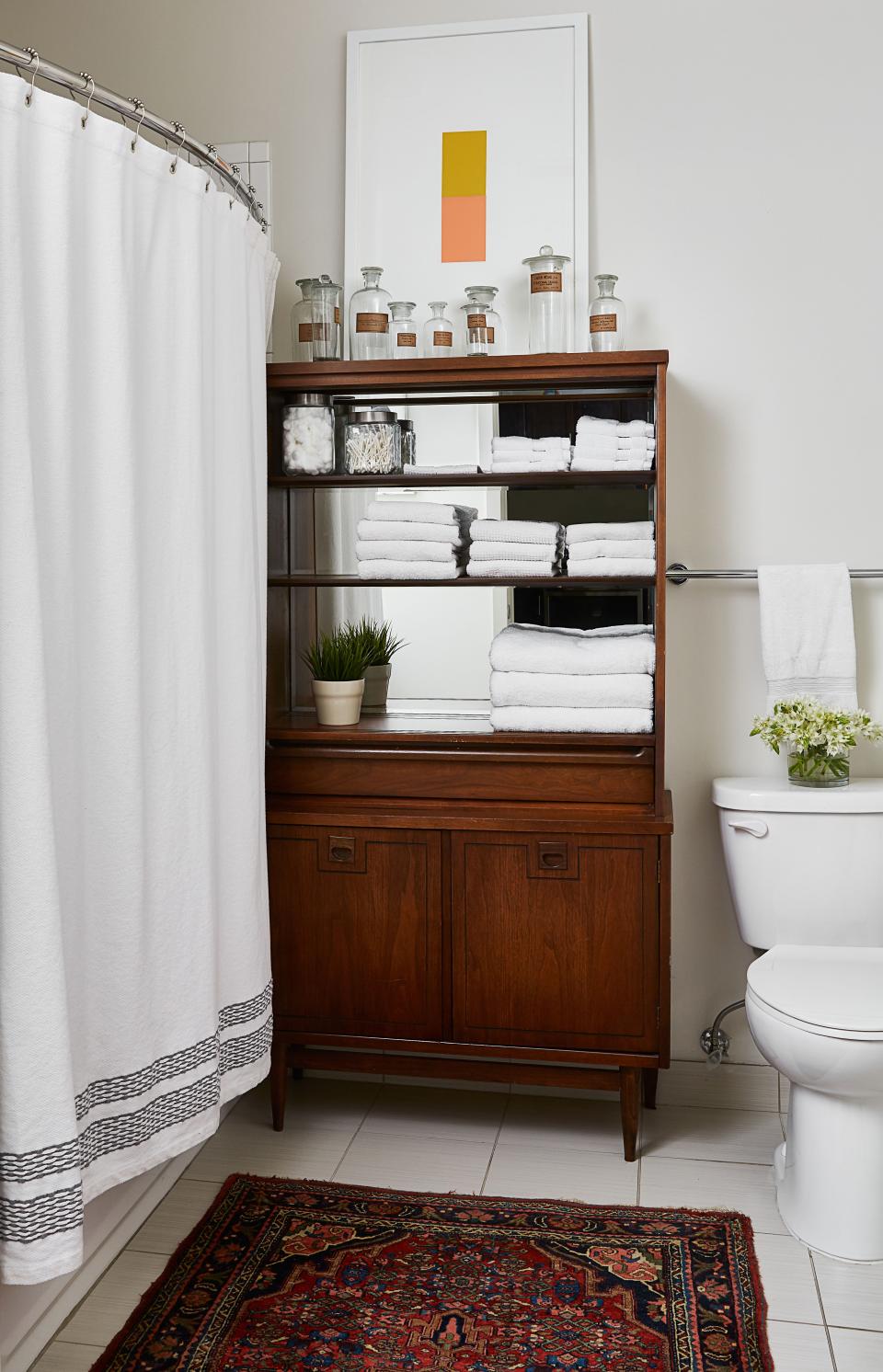 In Risdon’s bathroom, a cabinet purchased on eBay holds towels and vintage apothecary bottles. “That’s had three lives,” the designer says, pointing out that he previously used the piece as a bar, and before that as a china cabinet. Like the rest of the apartment, the bathroom displays Risdon’s flair for mixing old and new.