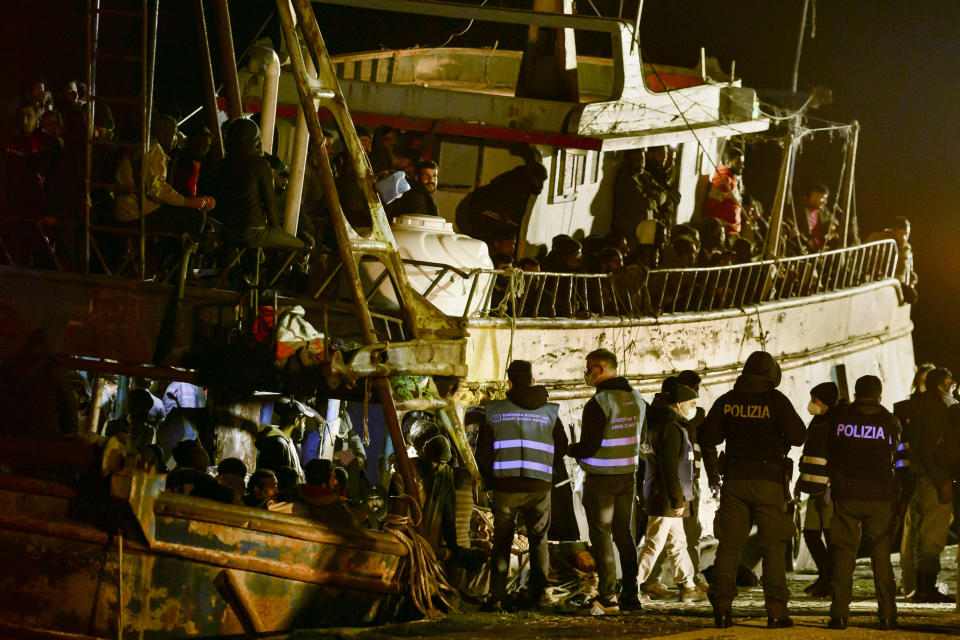 Police check a fishing boat with some 500 migrants in the southern Italian port of Crotone, early Saturday, March 11, 2023. The Italian coast guard was responding to three smugglers boats carrying more than 1,300 migrants “in danger” off Italy’s southern coast, officials said Friday. Three small coast guard boats were rescuing a boat with 500 migrants about 70 nautical miles off the Calabria region, which forms the toe of the Italian boot. (AP Photo/Valeria Ferraro)