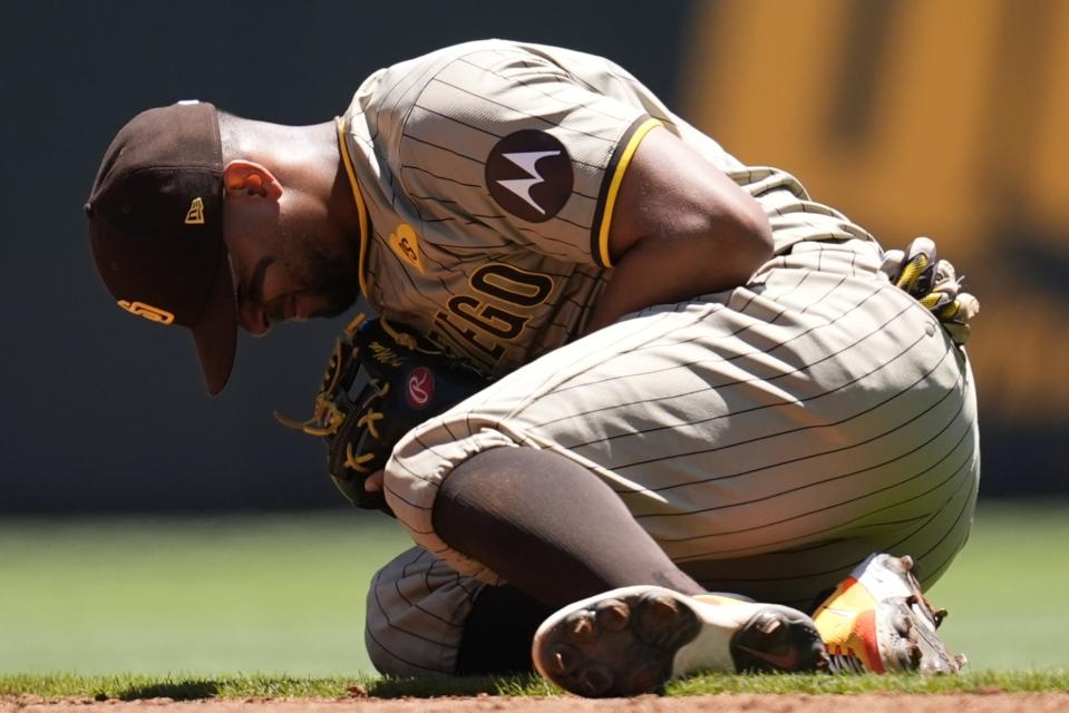 San Diego Padres second baseman Xander Bogaerts (2) kneels after injury fielding a ball hit by Atlanta Braves' Ronald Acuña Jr. in the third inning of a baseball game, Monday, May 20, 2024, in Atlanta. (AP Photo/Mike Stewart)