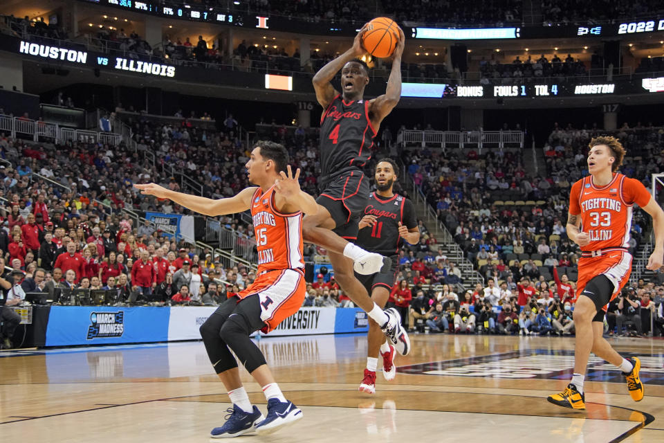 Houston 's Taze Moore (4) goes in for a layup over Illinois' RJ Melendez (15) during the first half of a college basketball game in the second round of the NCAA tournament in Pittsburgh, Sunday, March 20, 2022. Houston won 68-53. (AP Photo/Gene J. Puskar)