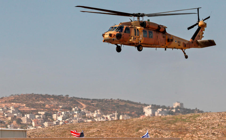 An Israeli airforce helicopter carrying US Secretary of State Mike Pompeo hovers over the settlers industrial park of Sha'ar Binyamin, with the Palestinian village of Burqa in the background, in the occupied West Bank on Nov. 19<span class="copyright">Ahmad Gharabli—AFP/Getty Images</span>