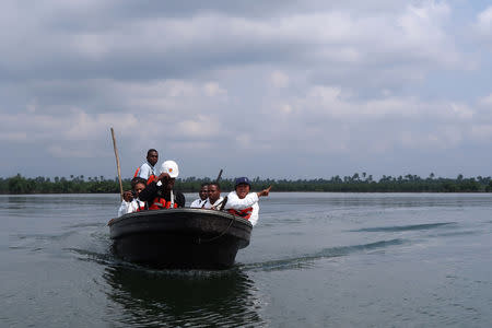 A team of the joint task force, part of the Bodo oil spill clean-up operation, ride a boat in the creeks near the village of Bodo which was hit by two oil spills in 2008, Nigeria August 2, 2018. REUTERS/Ron Bousso