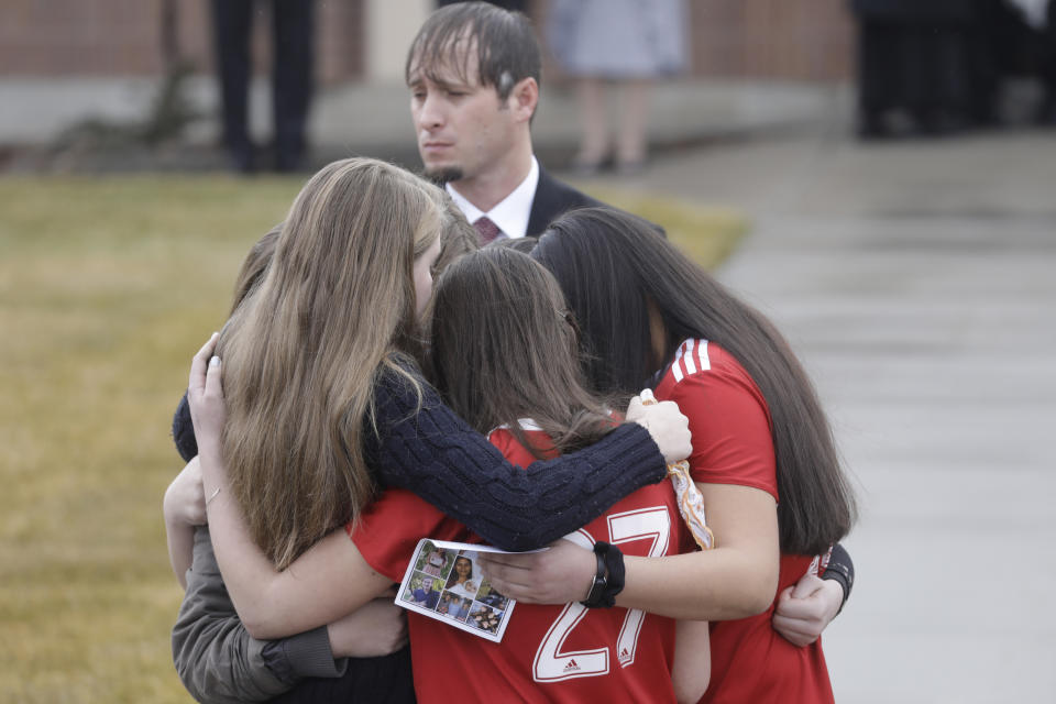 Mourners embrace following funeral services to remember a mother and three of her children who police say were killed by her teenage son Friday, Jan. 24, 2020, in Grantsville, Utah. Prosecutors say 16-year-old Colin "CJ" Haynie "methodically" killed his mother and siblings one by one as they returned home over a period of five hours on Jan. 17. Prosecutors have said the teenager shot his father in the leg before the older man wrestled a handgun away. (AP Photo/Rick Bowmer)