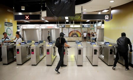 Anti-government protesters vandalize an entrance to the MTR station in Hong Kong