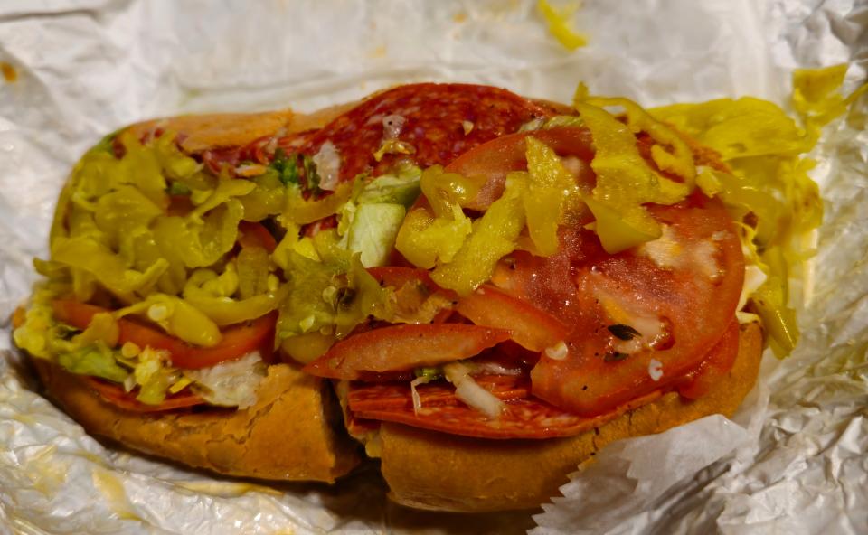 The Knuckle Sandwich at Graziano Bros. features coppa, hot soppressata, pepperoni, hot pepper cheese, sliced pepperoncinis, and Italian dressing, all on a hoagie roll.