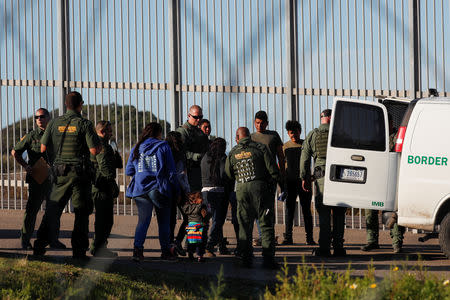 U.S. Customs and Border Protection (CBP) officials detain a group of migrants, part of a caravan of thousands from Central America trying to reach the United States, after they crossed illegally from Mexico to the U.S, as seen from Tijuana, Mexico, December 7, 2018. REUTERS/Carlos Garcia Rawlins