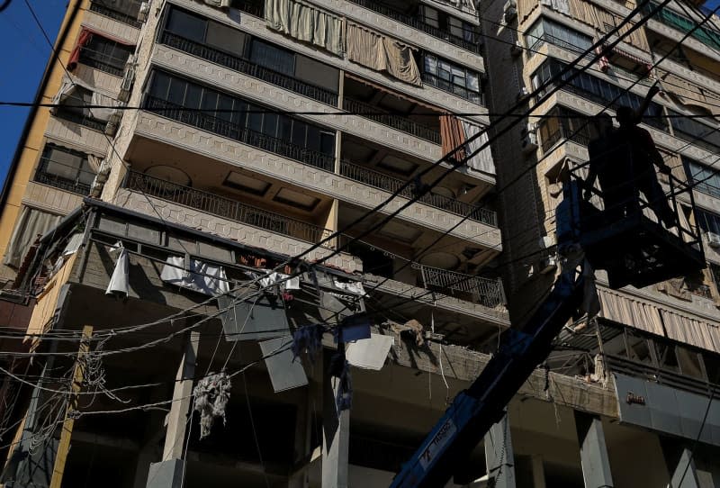 Lebanese employees work on dismantling electricity wires in front of an apartment in a building was targeted by an Israeli air strike in Beirut’s southern suburb. The attack targeted a top pro-Iranian Hezbollah commander. Marwan Naamani/dpa