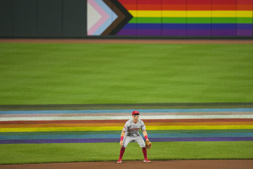 Cincinnati Reds shortstop Matt McLain stands near flags in honor of Pride Night in the seventh inning of a baseball game against the Baltimore Orioles, Wednesday, June 28, 2023, in Baltimore. (AP Photo/Julio Cortez)