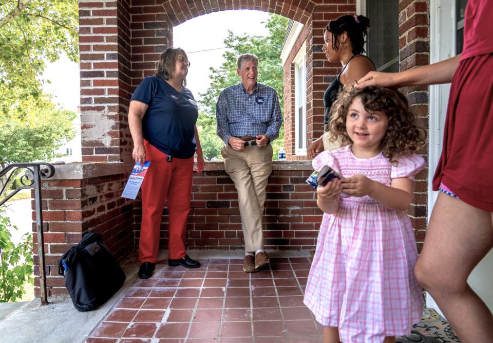 Gov. Dan McKee chats with resident Lauryn Harper on Aug. 20 as he canvasses in the Smith Hill district of Providence with Jo-Ann Ryan, left. At right, Jenny Shaw brings out daughter Nora to meet the governor.