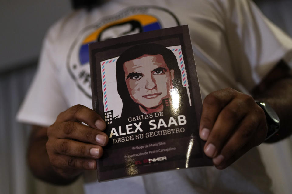 FILE - A member of the Free Alex Saab movement holds an image of Alex Saab during a press conference in Caracas, Venezuela, Aug. 15, 2022. The close ally of Venezuela's President Nicolas Maduro was extradited to the U.S. from Cabo Verde in June 2020, indicted on money laundering charges connected to an alleged bribery scheme that pocketed more than $350 million from a low-income housing project for the Venezuelan government. (AP Photo/Ariana Cubillos, File)