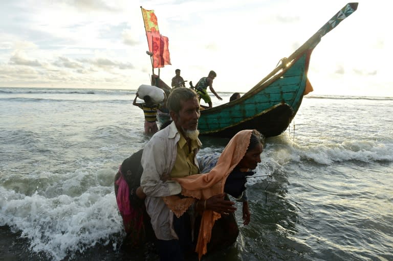 Rohingya refugees disembark from a boat after crossing the border from Myanmar, on the Bangladeshi shores of the Naf river in Teknaf on September 14, 2017