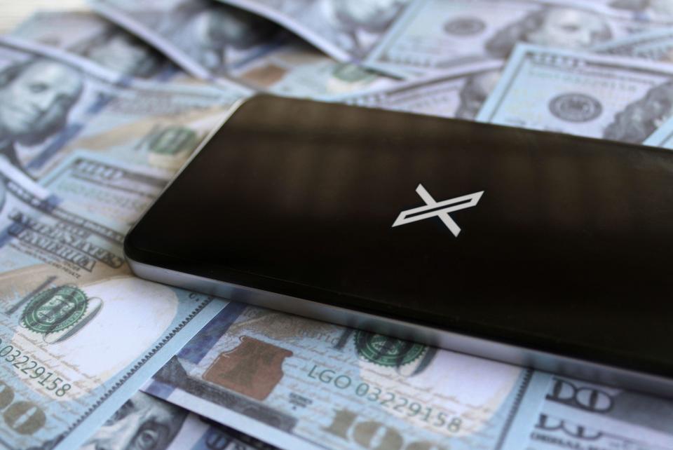 Social networking service X application logo on smartphone and money