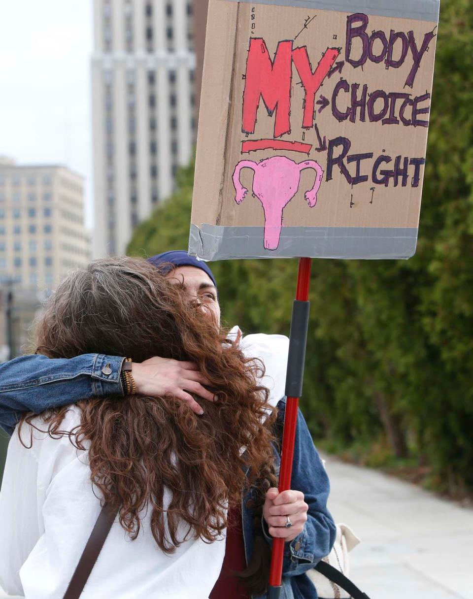 Abortion rights supporters greet each other as they arrive for a rally Tuesday in front of the Federal Building in downtown Akron.