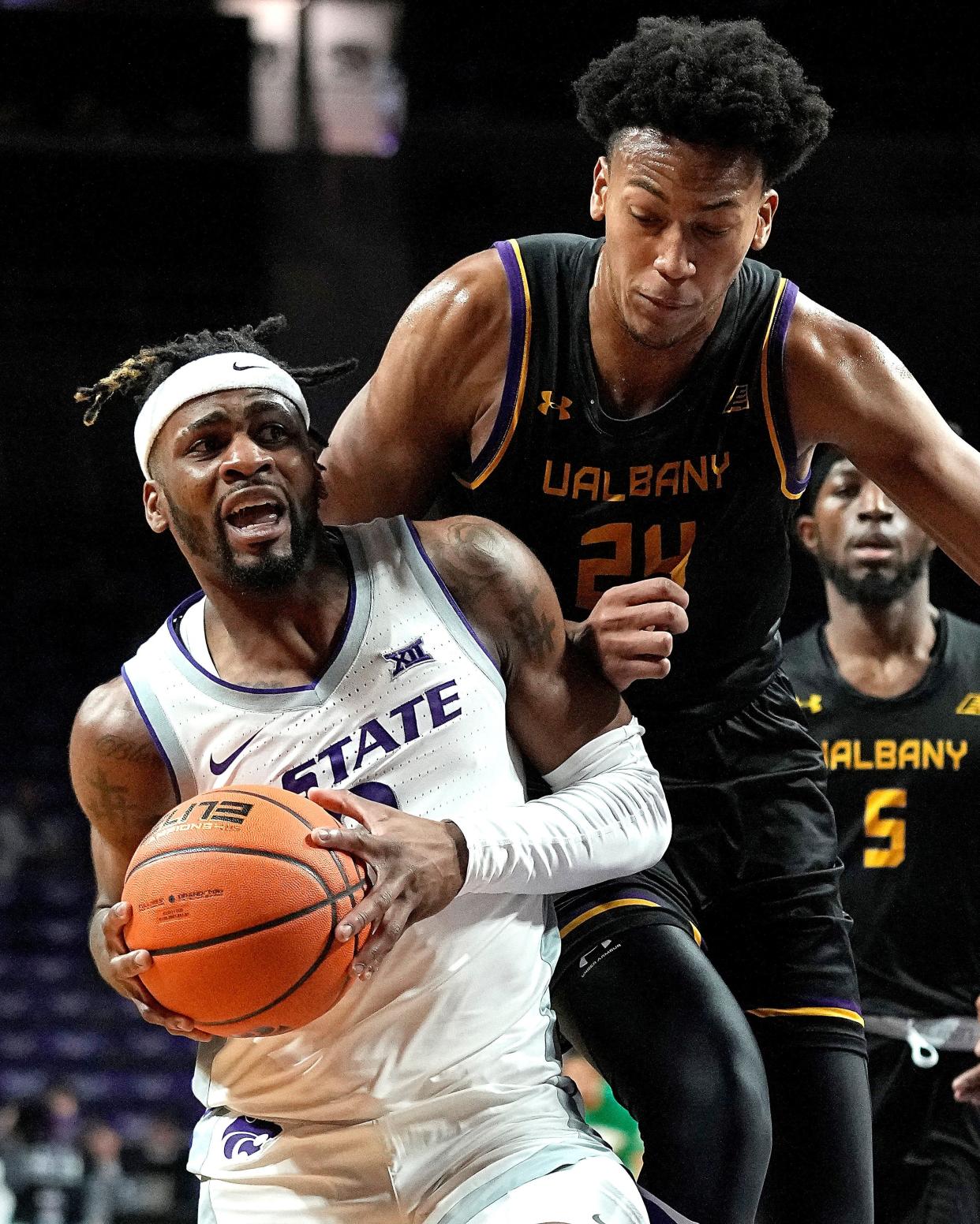 Kansas State's Selton Miguel, left, is pressured by Albany's Paul Newman (24) during the first half Wednesday night at Bramlage Coliseum.