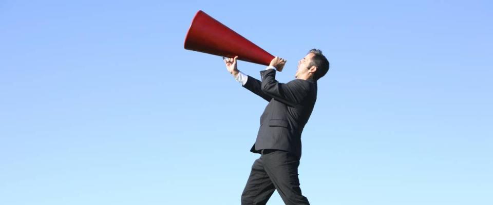 Man yelling into megaphone towards the sky