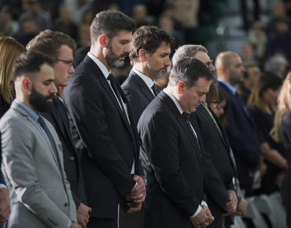 Edmonton Mayor Don Iveson, center left, Prime Minister Justin Trudeau, center, and Alberta Premier Jason Kenney pauses during a moment of silence during a memorial for the victims of the recent Ukrainian plane crash in Iran, in Edmonton, Sunday, Jan. 12, 2020. (Todd Korol/The Canadian Press via AP)