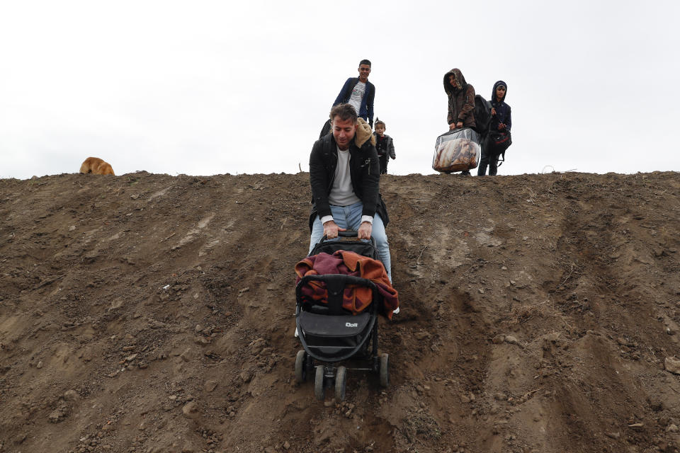 A migrant hods a baby-stroller as he comes down a slope in Edirne near the Turkish-Greek border on Thursday, March 5, 2020. Turkey has vowed to seek justice for a migrant it says was killed on the border with Greece after Greek authorities fired tear gas and stun grenades to push back dozens of people attempting to cross over. Greece had denied that anyone was killed in the clashes. (AP Photo/Darko Bandic)