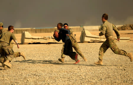 U.S. soldiers play a game of football on Thanksgiving Day inside the U.S. army base in Qayyara, south of Mosul, Iraq November 24, 2016. REUTERS/Thaier Al-Sudani