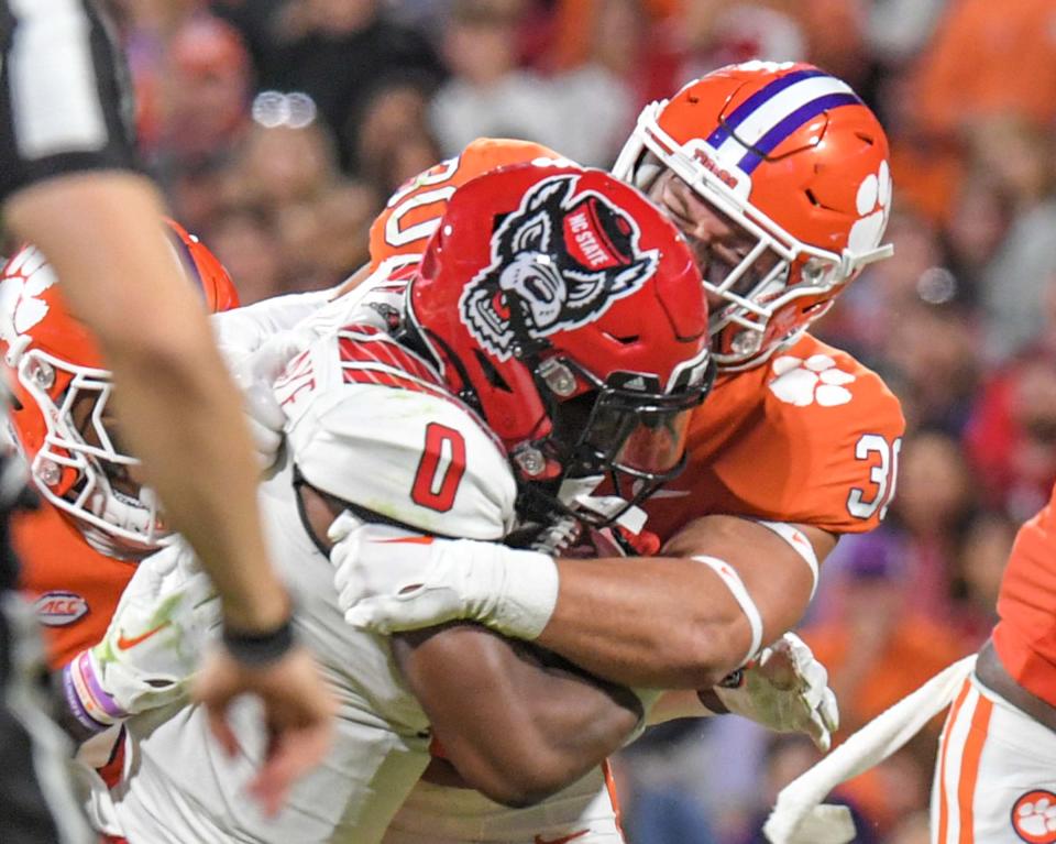 Clemson linebacker Keith Maguire (30) tackles North Carolina State Wolfpack running back Demie Sumo-Karngbaye (0) during the third quarter at Memorial Stadium in Clemson, South Carolina Saturday, October 1, 2022.  